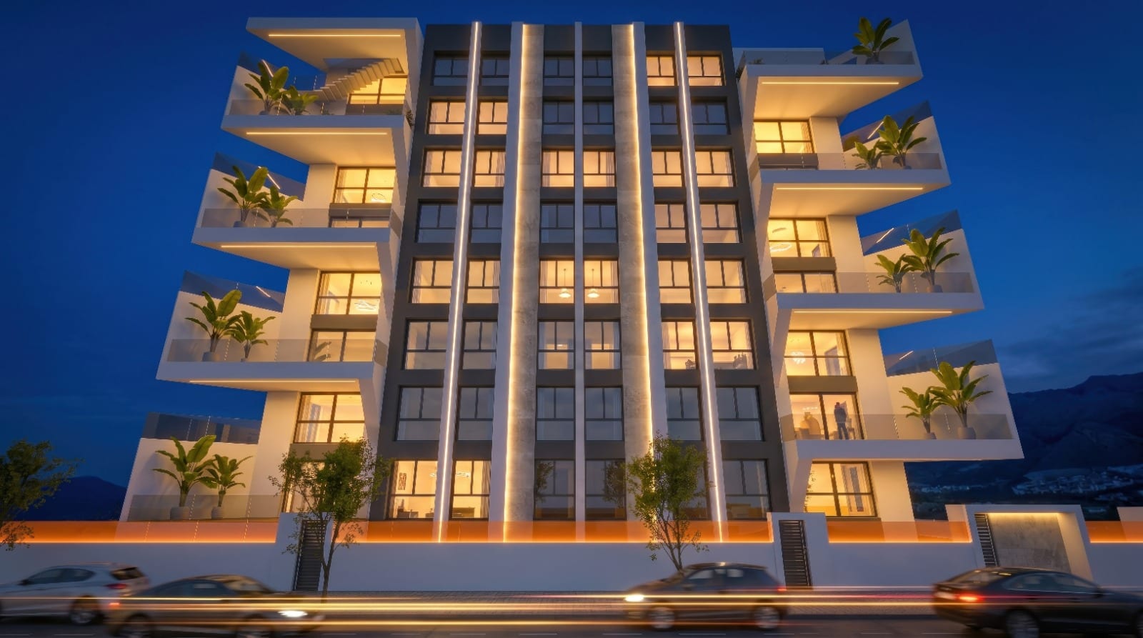 Infografía 3D de la fachada del edificio iluminada de noche, con terrazas en voladizo y vegetación en cada planta